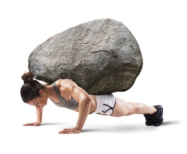Muscular woman lifts a boulder with back